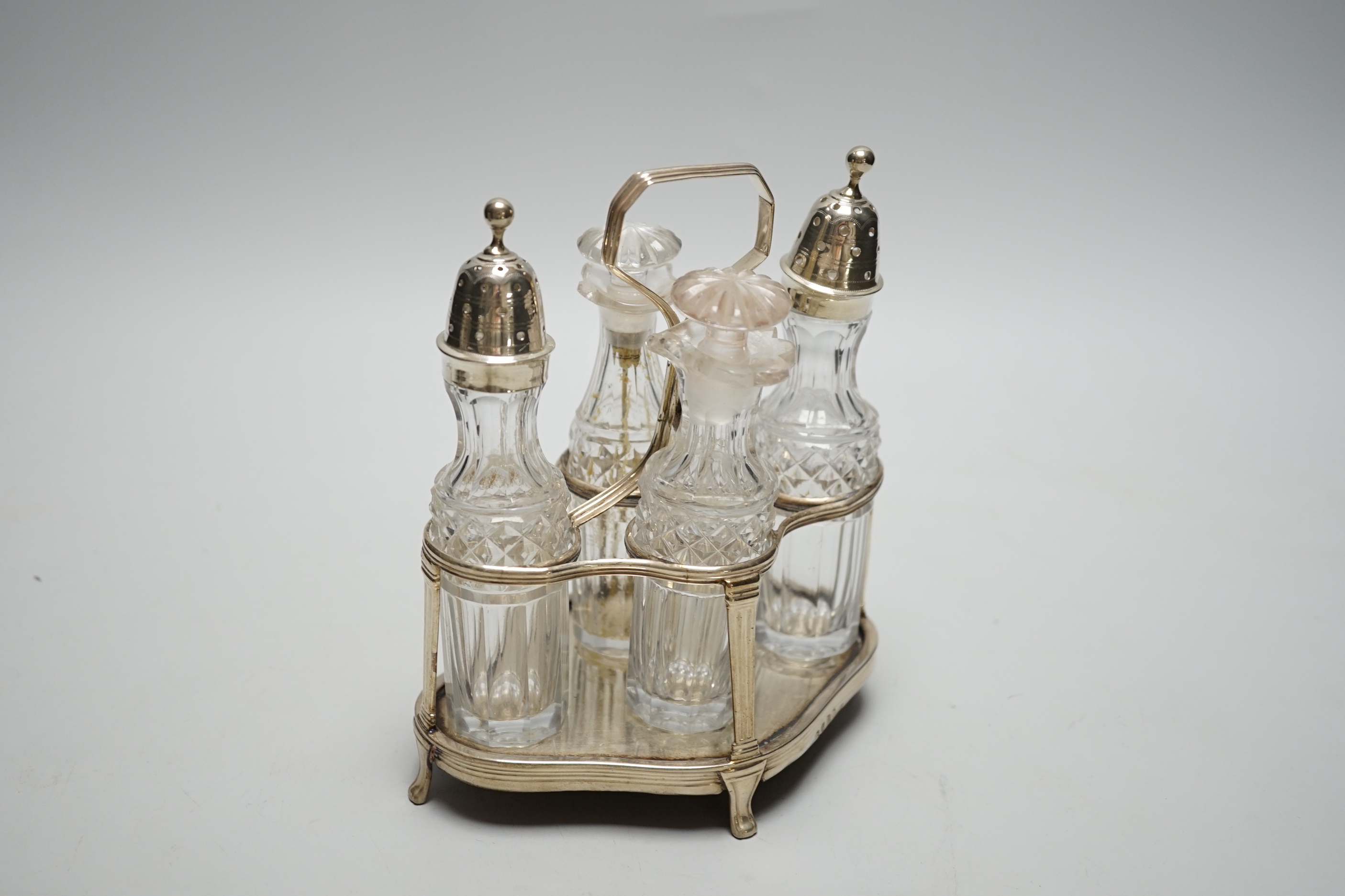 A George III small silver cruet stand, by Robert & David Hennell, London, 1799, of quatrefoil shape, with four associated glass bottles, two with silver mounts, height 17cm.